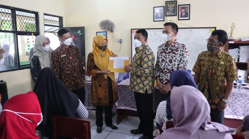 FOTO : Wakil Wali Kota Cilegon Sanuji Pentamarta menyerahkan simbolis Beasiswa kepada kepala Sekolah SDN Taman Sari II, Kamis (21/10/2021). Amul/megatrust.co.id