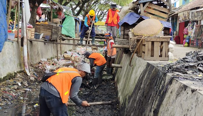 Kali Belakang Pasar Keranggot Dibersihkan Secara Manual. Pedagang Masih Berjejer