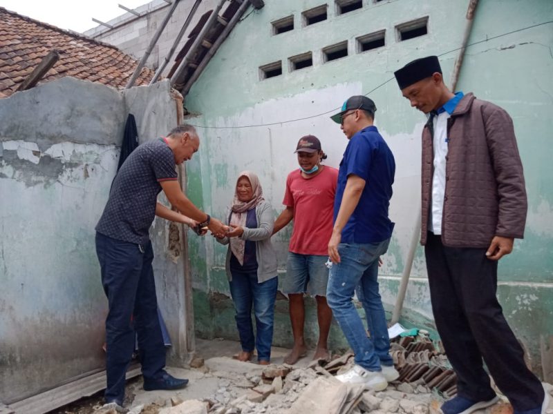 Ketua DPD PAN Kota Cilegon Alawi Mahmud dan Rahmatulloh memberikan bantuan kepada Sri Hartini untuk merehab rumahnya. (Amul/Megatrust.co.id)